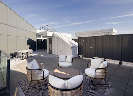 A patio with white chairs and a table.