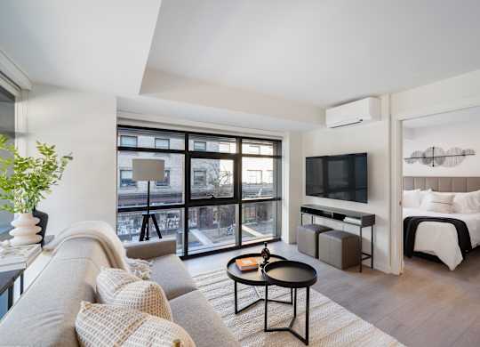 A living room with a grey couch and a black coffee table.