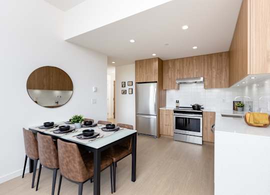 A modern kitchen with a dining table and chairs.