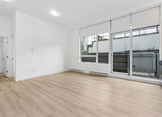 A room with a white wall and a wooden floor.