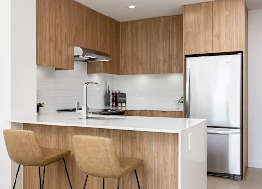 A modern kitchen with wooden cabinets and a white countertop.