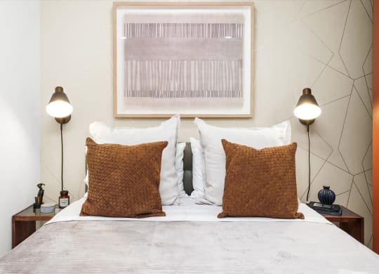 a bedroom with a bed with two pillows and two lamps