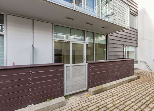 A building with a brown wall and a grey door.