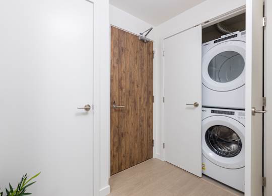 A white door is open to a laundry room with a washer and dryer.