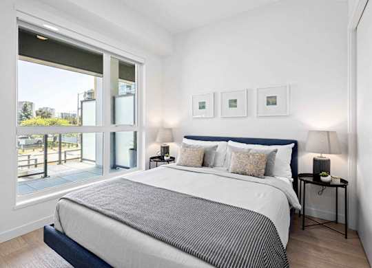 A bedroom with a large bed and a view of the outside.