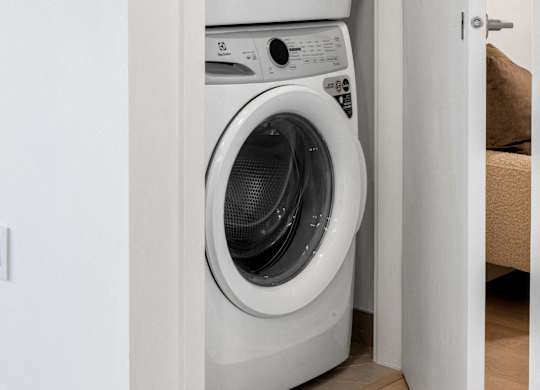 Two white front loading washing machines in a small room.