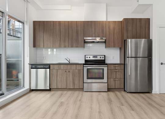 A modern kitchen with wooden cabinets and stainless steel appliances.