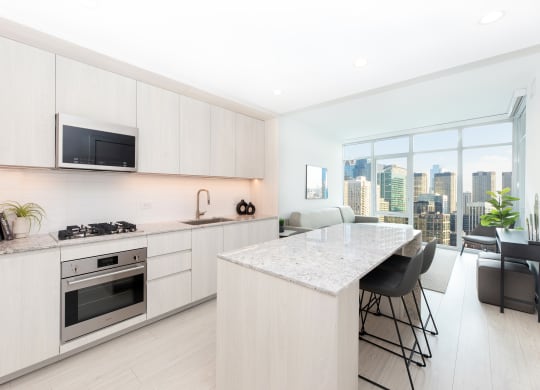 a kitchen with white cabinets and a marble counter top