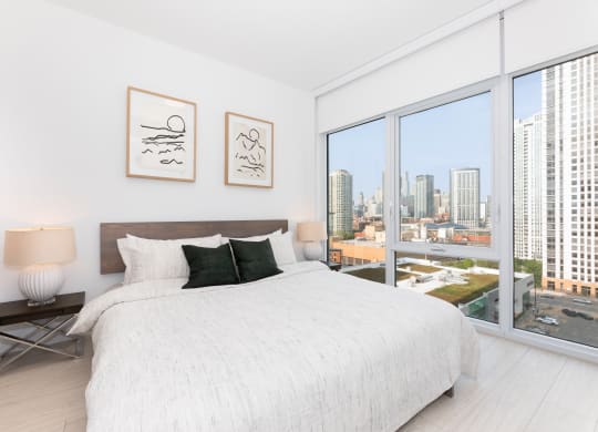a bedroom with a large bed next to a window