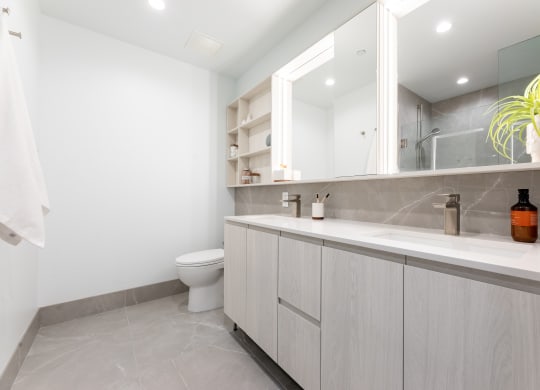 a bathroom with white cabinets and a white toilet