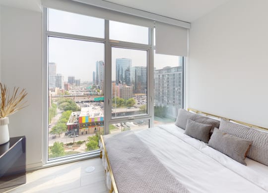 a bedroom with a bed and a large window