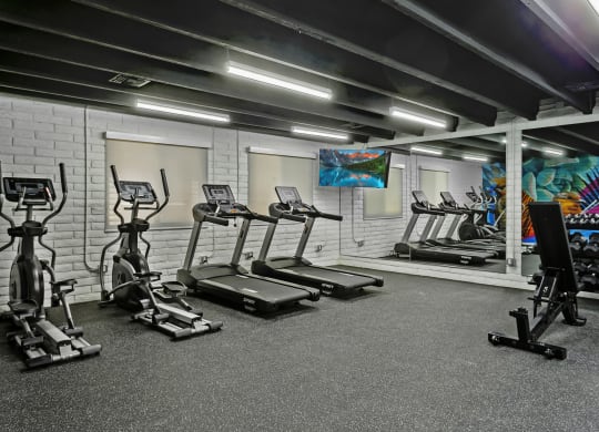a spacious fitness center with treadmills and other exercise equipment
