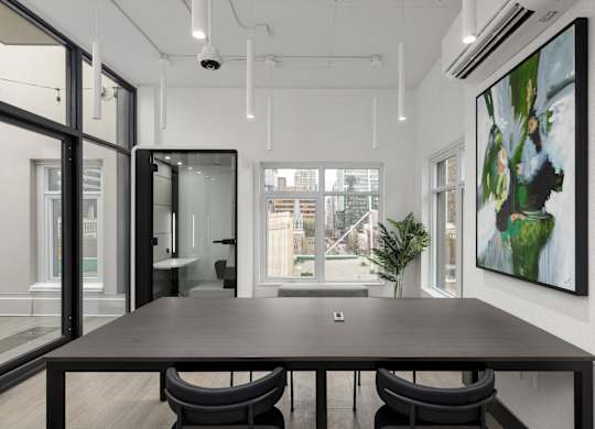 A modern conference room with a long table and chairs.
