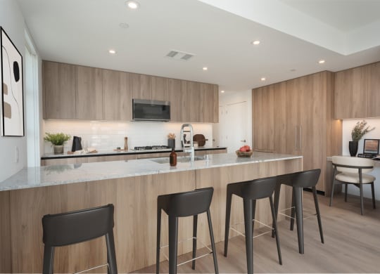a kitchen with a marble counter top and three stools