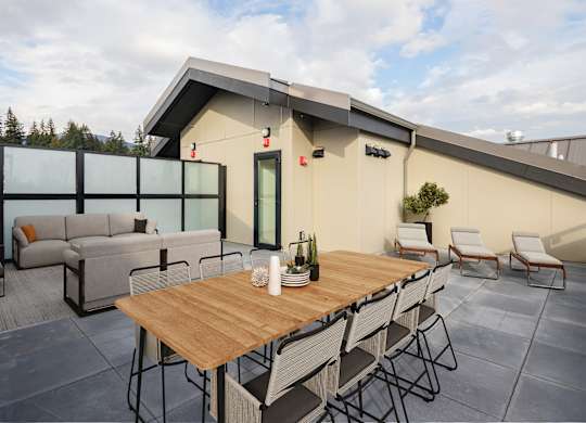 A patio with a table and chairs is set up outside a house.