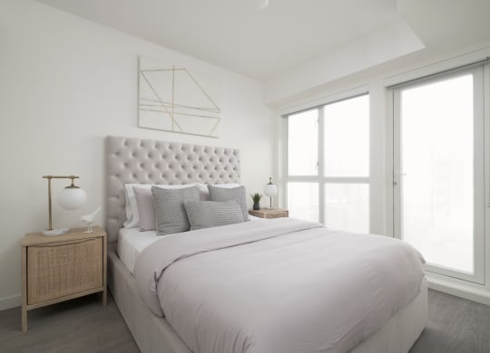 a white bedroom with a large bed and a window