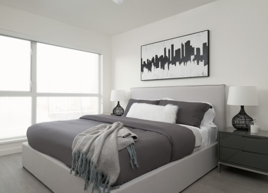 a black and white bedroom with a bed and a large window