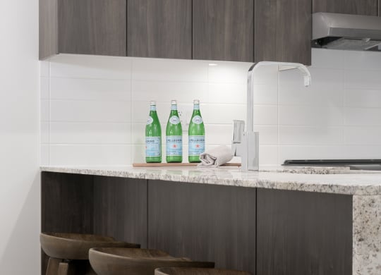a kitchen with three wooden stools in front of a counter top