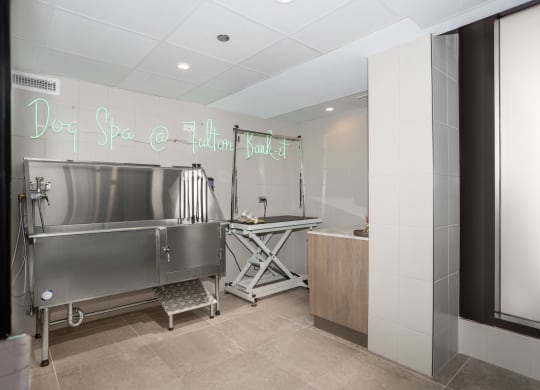 a view of the dog spa area with a large stainless steel tub in the foreground and a