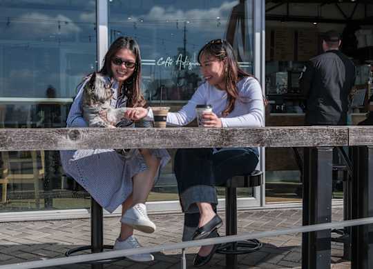 Two women sitting at a table with a dog.