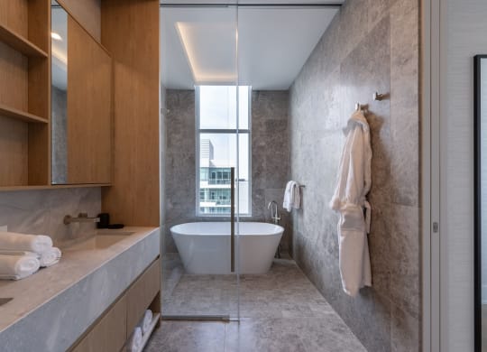 a bathroom with a white bathtub and a large window