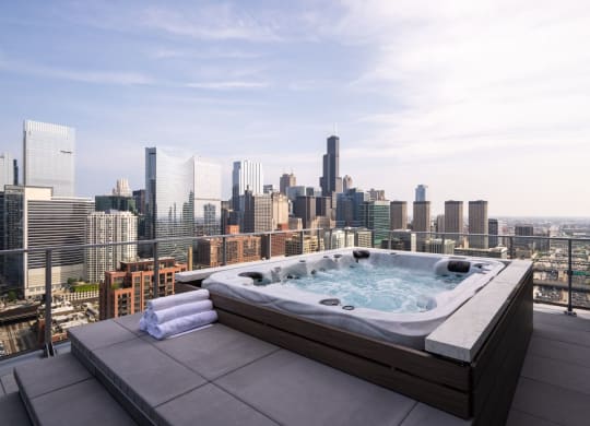 an outdoor jacuzzi on a balcony with a view of the chicago skyline