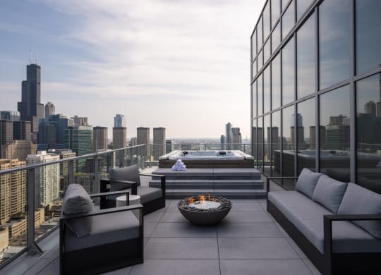 a terrace with a fire pit and a view of the chicago skyline