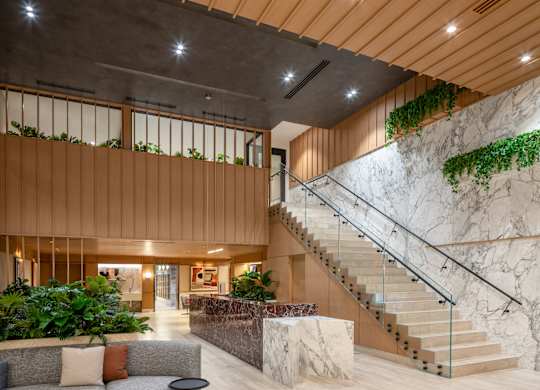A modern living room with a staircase and a couch.