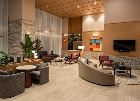 A living room with a sofa, chairs, and a TV.
