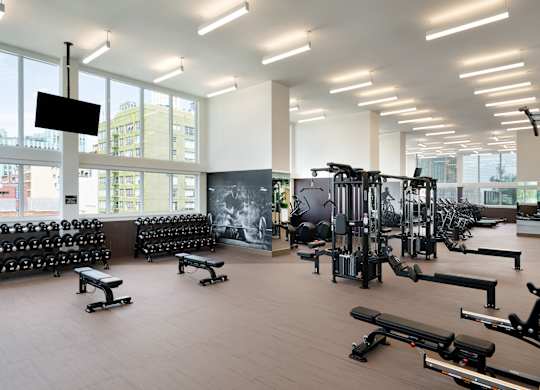 A gym with a variety of equipment including weights and machines.