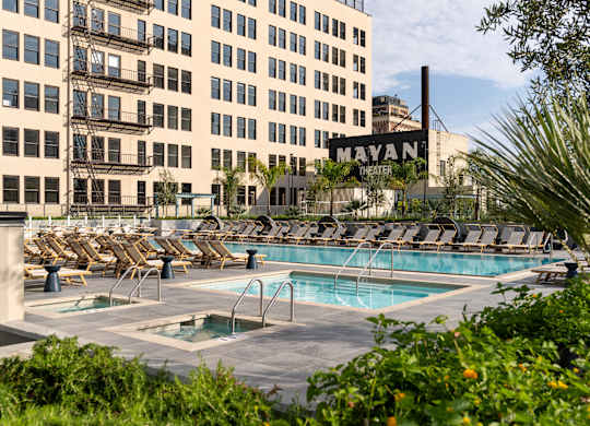 A pool area with chairs and a sign that says Mayan.