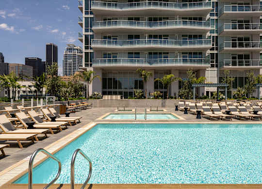 A large swimming pool in front of a multi-story building.