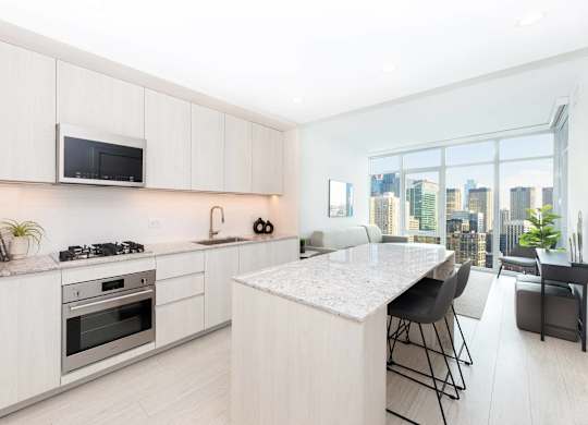 A modern kitchen with white cabinets and a large island.