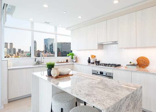 A kitchen with a marble countertop and a view of the city.