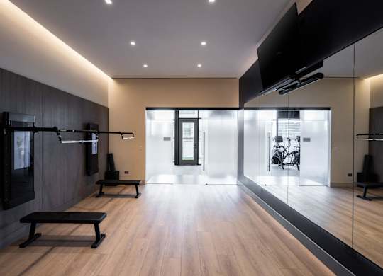 A gym with wooden floors and a variety of equipment.