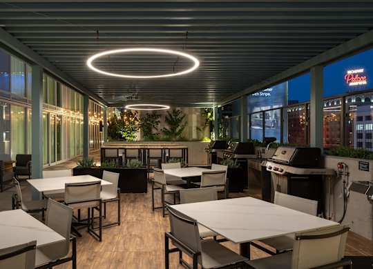 A restaurant with tables and chairs and a bar area.