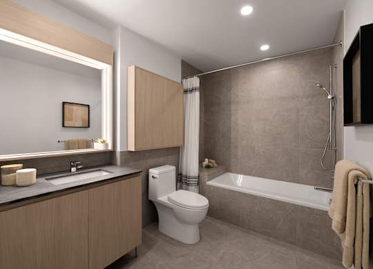 A modern bathroom with a toilet, sink, and bathtub.