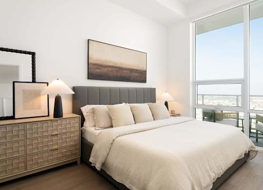 A bedroom with a large bed and a painting on the wall.