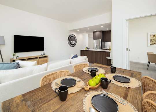 A modern dining room with a wooden table set for four.