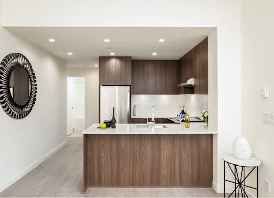 A modern kitchen with a wooden island and a large mirror on the wall.