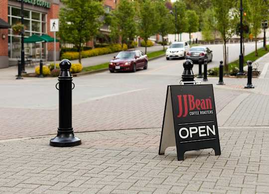 A sign that says JBean Coffee Roasters is on the sidewalk.