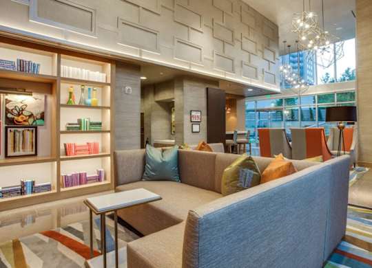 A living room with a couch, a coffee table, and a bookshelf.