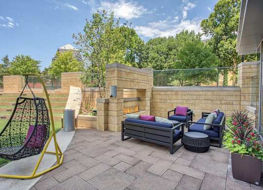 A backyard with a swing chair, a couch, and a table.