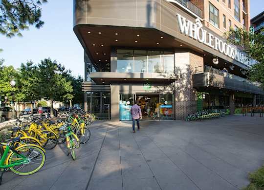 A Whole Foods Market store with a man walking in front.