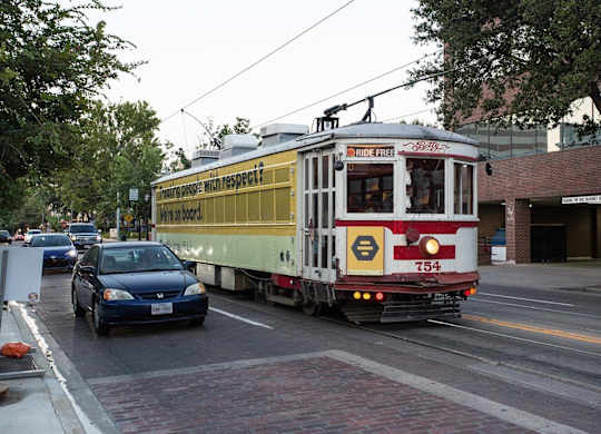 A streetcar with a sign that says "ride free" is on a city street.