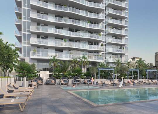 A large white building with a pool in front.