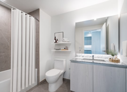 a bathroom with a toilet and a sink and a shower