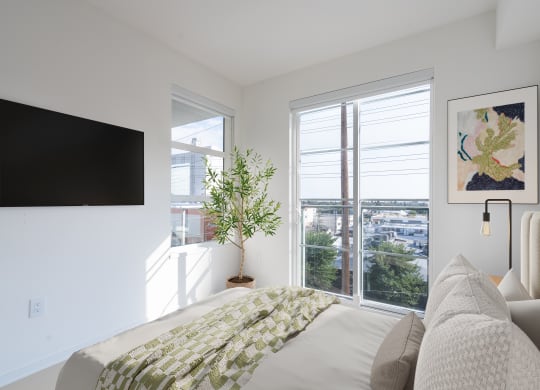 a bedroom with a bed and a tv on the wall