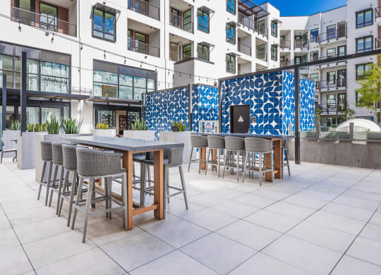 an outdoor patio with tables and chairs and a building in the background