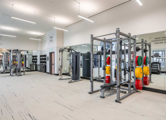 a gym with fitness equipment and mirrors on the wall
